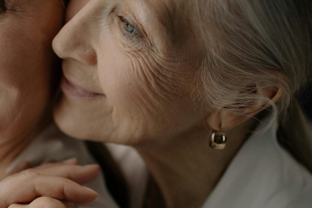 Heartwarming close-up photo of a smiling elderly woman showing affection.
