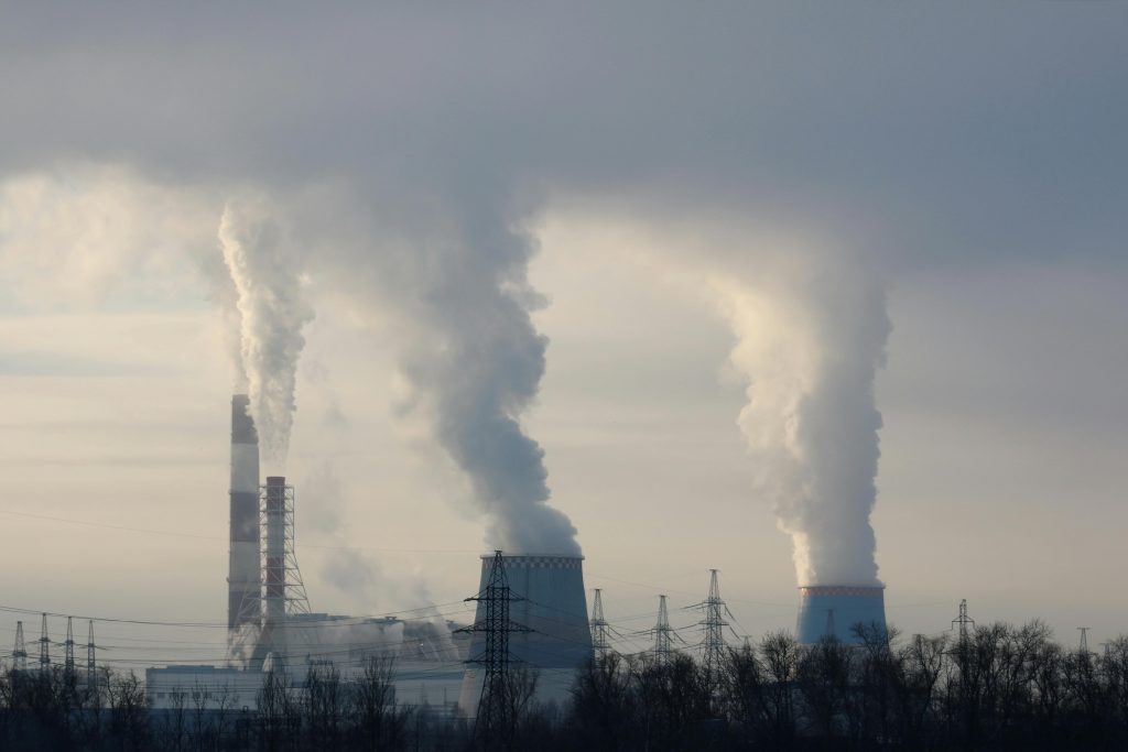 Smoke billowing from industrial smokestacks, contributing to air pollution in the atmosphere.