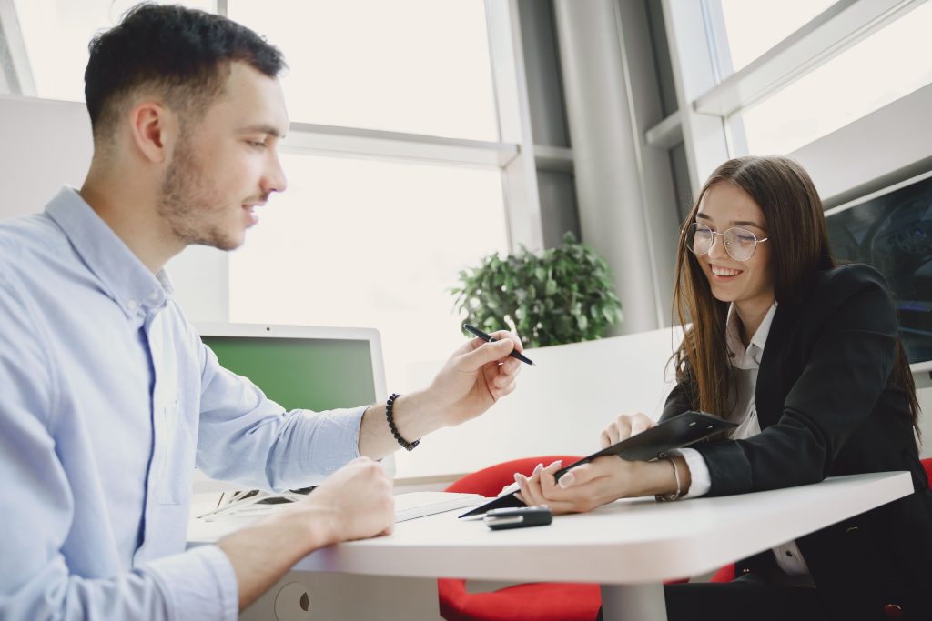 Man and woman discussing business at a bright modern office table.